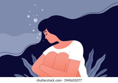 The unhappy girl sits and hugs her knees in a sea of her own sorrow. Sad lonely woman in depression with flying hair. Concept of a person trapped in the bottom due to stress