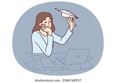 Unmotivated woman freelancer procrastinating sitting at office desk with laptop and launching paper planes. Unmotivated office worker needs support from manager or help with burnout.