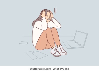 Upset cold woman suffering from stress or burnout, sitting on floor near papers and laptop. Problem of burnout in freelancer girl who suffered due to overload and mental pressure from manager