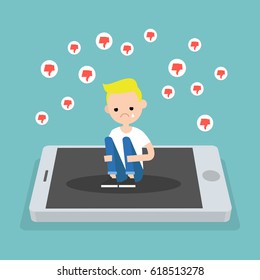 Upset crying blond boy sitting on the mobile's screen and hugging his knees surrounded by the dislike symbols / editable flat vector illustration, clip art