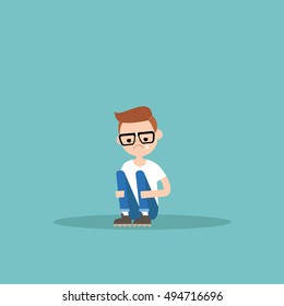 Upset crying nerd boy sitting and hugging his knees / editable flat vector illustration