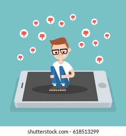 Upset crying nerd sitting on the mobile's screen and hugging his knees surrounded by the dislike symbols / editable flat vector illustration, clip art