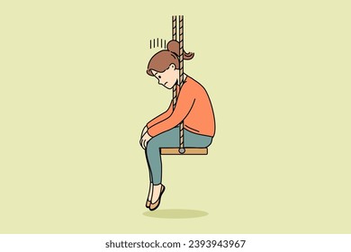 Upset little girl sits on swing with head down after parents divorce or reprimand at school. Upset schoolgirl is sad because of problems with friends who do not want to go out together