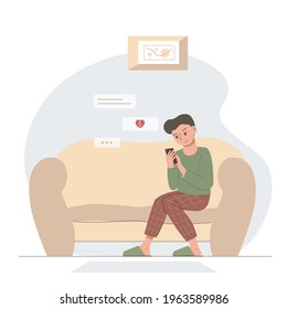 Upset man sitting on the sofa. A guy with a broken heart reads messages on the phone.