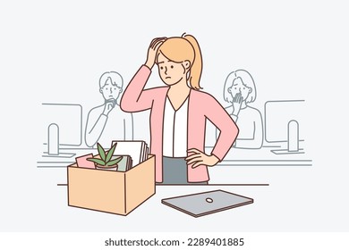 Upset woman standing near table with box after dismissal of manager or secretary position. Sad girl is preparing to leave workplace due to dismissal related to financial crisis or closure of company
