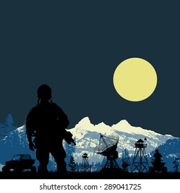 US soldier guarding the base satnav in the forest at mountain background
