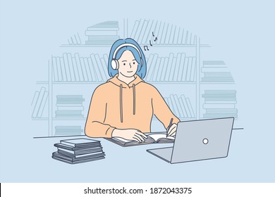 Using gadgets, listening to music during e-learning concept. Smiling teen girl college student with blue hair in headphones watching online webinar or online tutorial on laptop and making notes 