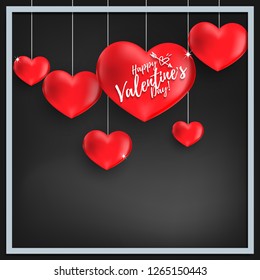 Valentine's day background of a group of red hearts hanging with Happy Valentine's Day text and square frame on black background for your copy space. Concept of love and Valentines day design.