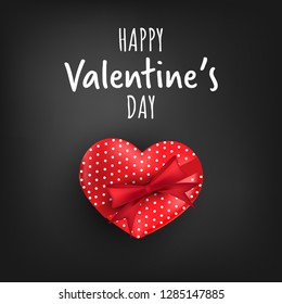 Valentine's day background of red heart shape gift box with red ribbons and Happy Valentine's Day text on black background. Valentine's day concept for background, advertising and promotion.