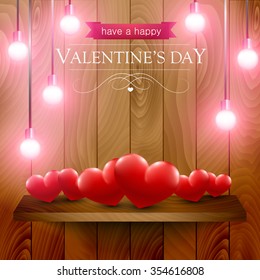 Valentines day card with heart on a wooden shelf illuminated with pink lights.
