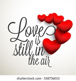 Valentines Day Celebration with text Love is Still in the Air and glossy hearts on grey background.