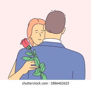Valentines Day. Couple in love. Young happy girlfriend hugging boyfriend and holding rose.