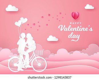 Valentine's Day greeting card. couple sitting at one bicycle and looking each other with one hand holding heart shaped balloons on pink background. paper cut style vector illustration