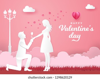 Valentine's Day greeting card. Young man kneeling to his girlfriend and giving a rose on the park with heart and pink background. paper cut style vector illustration