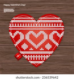 Valentine's knitted heart on a wood background can be used as a greeting card