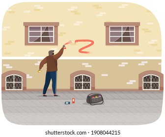 Vandal damaging city building. Bully in hood and balaclava painting graffiti on a brick wall of a residential building. Street gangsters and vandalism concept. A man bandit destroy city property