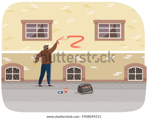 Vandal damaging city building. Bully in hood and
balaclava painting graffiti on a brick wall of a residential
building. Street gangsters and vandalism concept. A man bandit
destroy city property