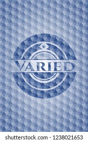 Varied blue emblem or badge with abstract geometric pattern background.