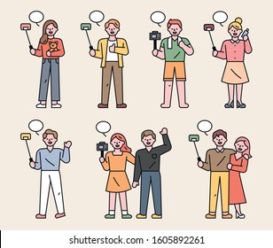 A variety of people are holding a selfie stick and shooting private broadcasts. flat design style minimal vector illustration.