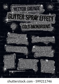 Various silver glitter spray paint graffiti on brick wall.
