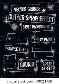 Various silver glitter spray paint graffiti on brick wall.