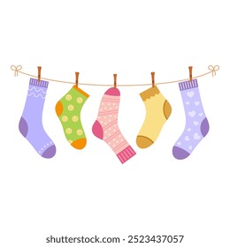 various socks on clothesline with clothespins, cotton and wool socks on rope, apparels with different patterns for men, women and kids