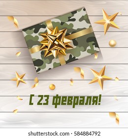 Vector 23 February greeting card with gift for men with military rexture on  wooden background, gold stars and confetti. Happy men's day. Translation: Happy 23 february!