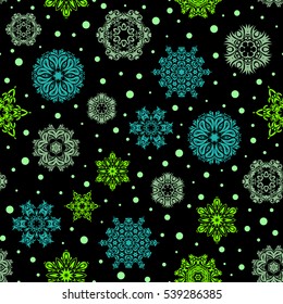 Vector abstract design in blue and green colors. Seamless pattern of blue and green snowflakes and dots on black background.