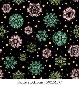 Vector abstract design in green and yellow colors. Seamless pattern of green and yellow snowflakes and dots on black background.