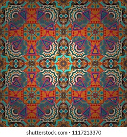 Vector abstract geometric kaleidoscopic mandala design symbol - symmetric. Seamless pattern from mandalas painted in orange, pink and blue colors.