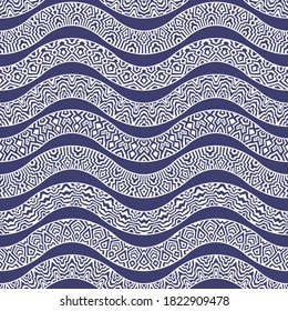 Vector abstract seamless pattern from art deco lacy waves .Horizontal beige snake skin tribal ornaments on a dark indigo blue background. Wallpaper, wrapping paper. Folk, ethnic batik