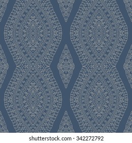 Vector abstract seamless pattern from light beige hand drawn outline geometrical rhombus, Eskimo ornaments, wavy stripes on a dark grey blue. Textile fantasy print. Wrapping paper. Batik painting