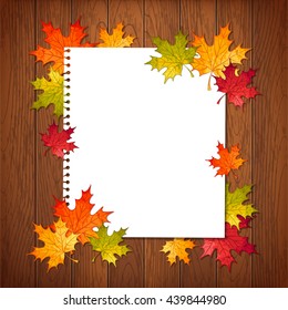 Vector autumn illustration of colorful maple leaves and paper sheet on wooden table background