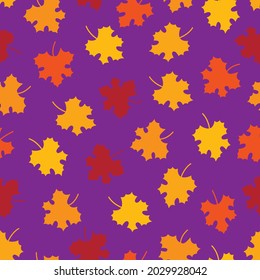 Vector autumn seamless pattern. Red, yellow, orange maple leaves silhouettes on violet background. Design for textile, wallpaper, wrapping paper, notebook cover.