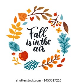 Vector autumn wreath with falling leaves, apple, rowan, fall floral elements and hand written quote "Fall is in the". Bright round frame made from hand drawn botanical elements. Isolated on white.