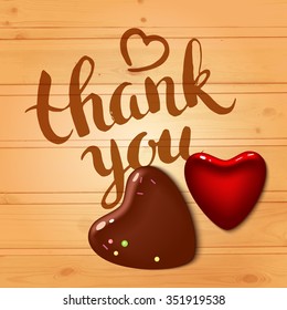 Vector background with chocolate hearts on the wood table. Inscription - Thank you.  Brushstroke with rough edges. Calligraphy. Ink. Lettering. Sketch. Valentines day.