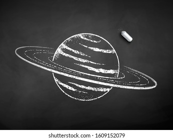 Vector black and white chalk drawn illustration of Saturn planet with piece of chalk on black chalkboard background.