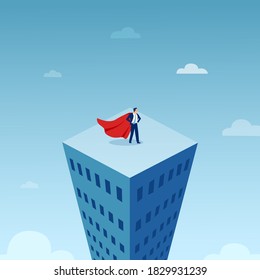 Vector of a businessman in red cape on top of the tall city building