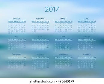 Vector calendar for 2017 year with abstract blue blurred background. Week starts on monday