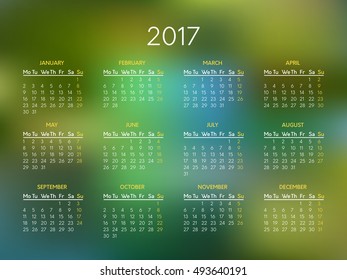 Vector calendar for 2017 year with abstract green blurred background. Week starts on monday