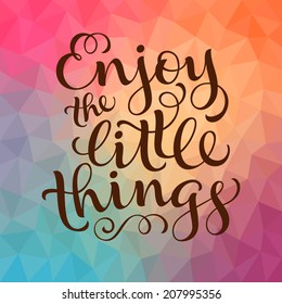 Vector calligraphic inscription with ornamental elements on colorful geometric background. "Enjoy the little things" poster or postcard. Typography collection