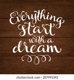 Vector calligraphic inscription with ornamental elements on wood background. "Everything start with a dream" poster or postcard. Typography collection