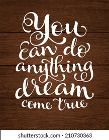 Vector calligraphic inscription with ornamental elements on wood background. "You can do anything dream come true" poster or postcard. Typography collection