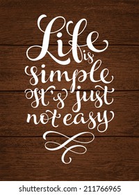 Vector calligraphic inscription with ornamental elements on wood background. "Life is simple. It's just not easy" poster or postcard. Typography collection