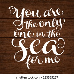 Vector calligraphic inscription with ornamental elements on wood background. "You are the only one in the sea for me" poster or postcard. Typography collection