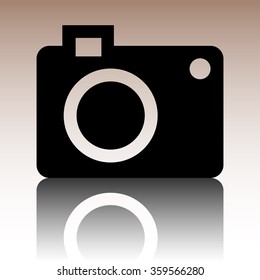Vector camera icon. Black vector illustration with reflection.