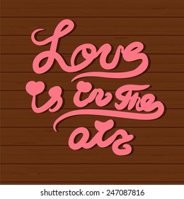 Vector card with hand lettering  text "Love is in the air" and cartoon flowers  on wood background. Valentine`s day, mother`s day, wedding or birthday card design.