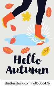 Vector card - Hello Autumn. Funny illustration of woman legs in rubbers boots walking in the puddle. Falling yellow and orange leaves around. Hand drawn lettering