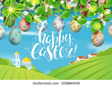 Vector card with realistic decorated 3D eggs hang on and blossom cherry tree. Handwritten calligraphy iinscription Happy Easter. Bright sunny background with village and church. Landscape.