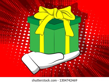 Vector cartoon hand holding big gift box. Illustrated holiday sign on comic book background.